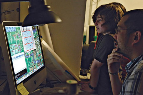 Mokytojas padeda vaikams kurti kompiuterinį žaidimą